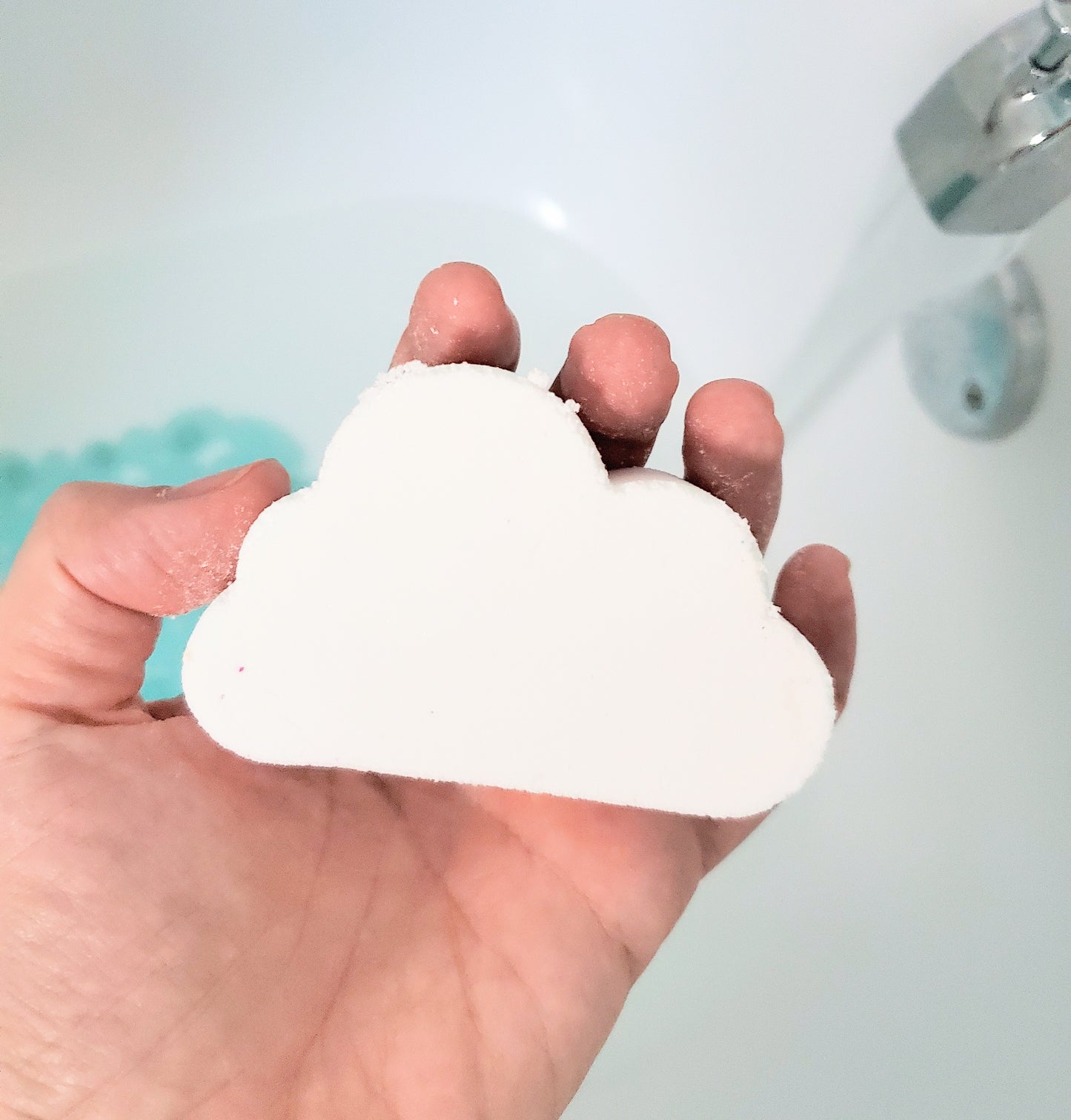 rainbow cloud bath bomb held in hand